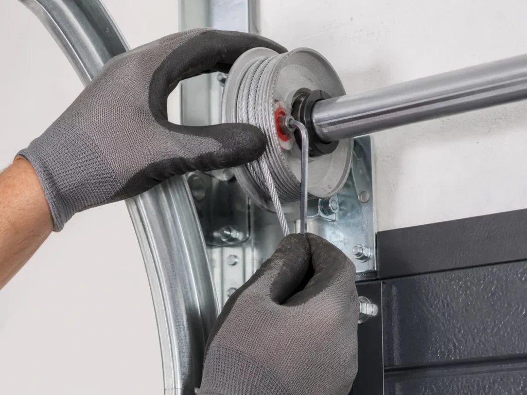 Serrage de la vis d'un tambour à câble de porte de garage à la clé Allen