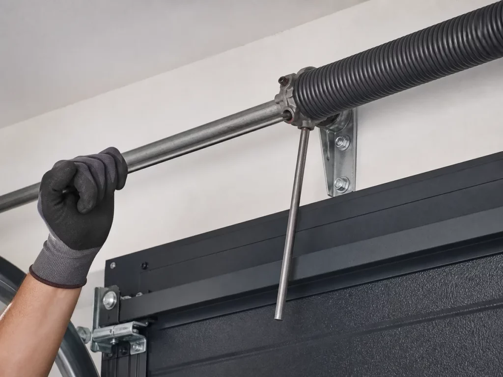 Barres de tension engagées dans le moyeu d'un ressort de torsion de porte de garage