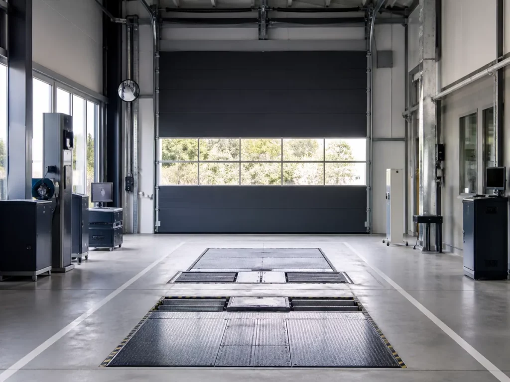 Porte sectionnelle industrielle vitrée dans un centre de contrôle technique automobile