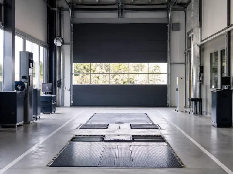 Porte sectionnelle industrielle vitrée dans un centre de contrôle technique automobile