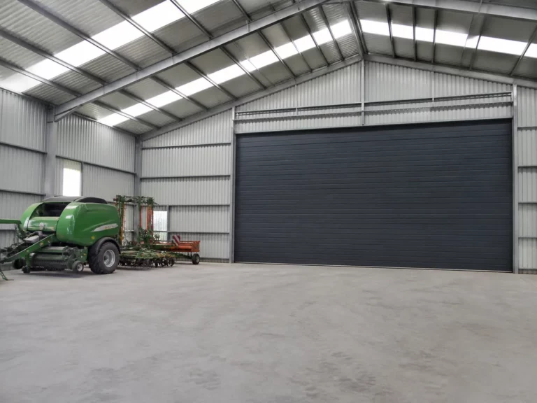 Porte sectionnelle industrielle fermée dans un hangar agricole en structure métallique