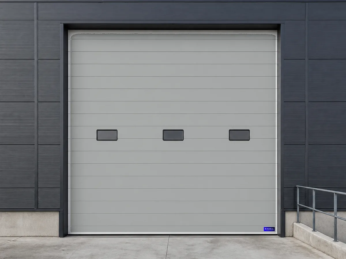 Porte industrielle grise à hublots pour un bâtiment logistique
