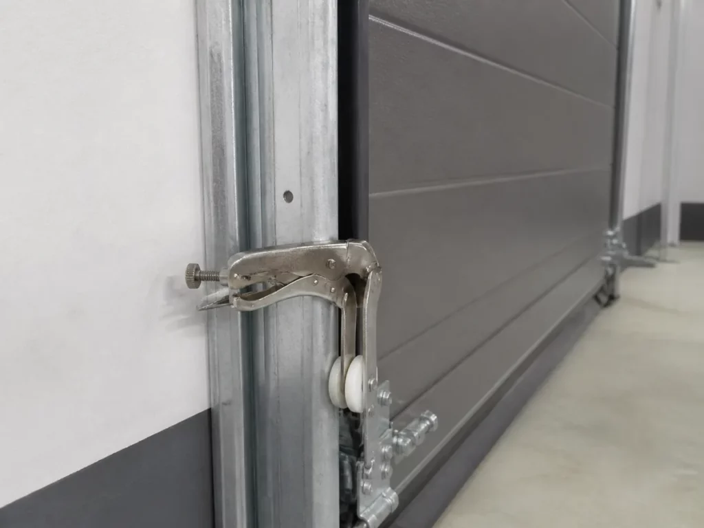 Serre-joint posé sur le rail vertical d'une porte de garage pour l'empêcher de descendre