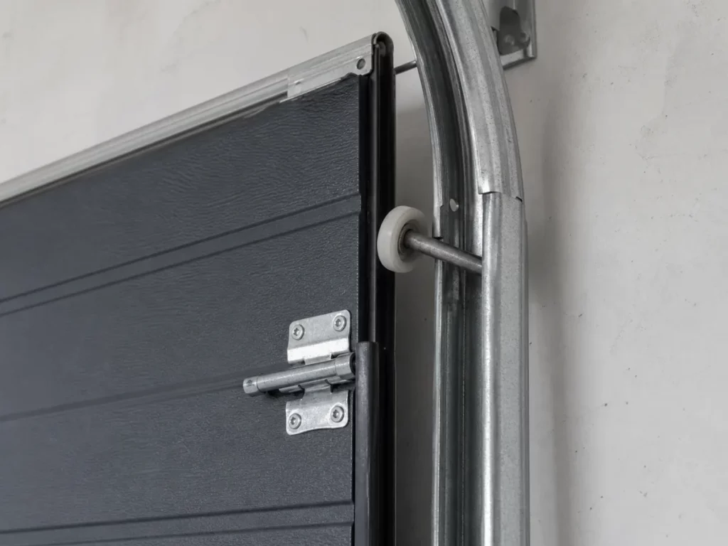 Galet de porte sectionnelle en nylon sorti de son rail d'acier galvanisé