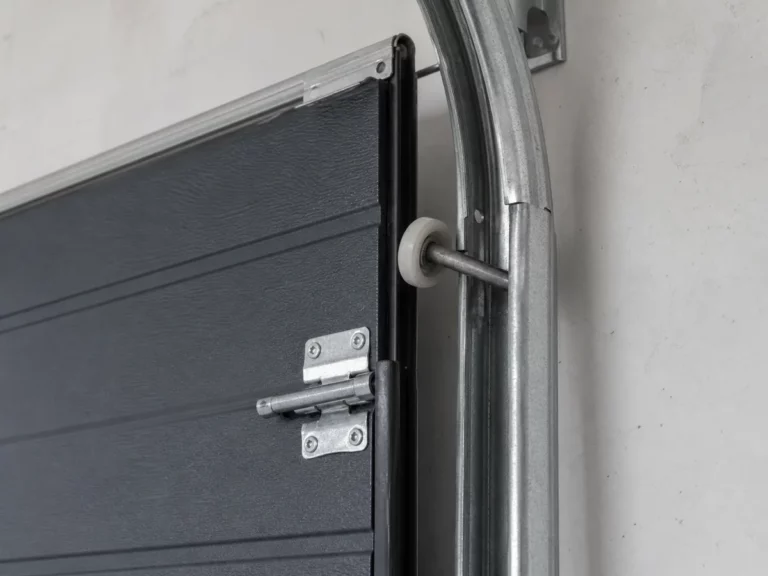 Galet de porte sectionnelle en nylon sorti de son rail d'acier galvanisé