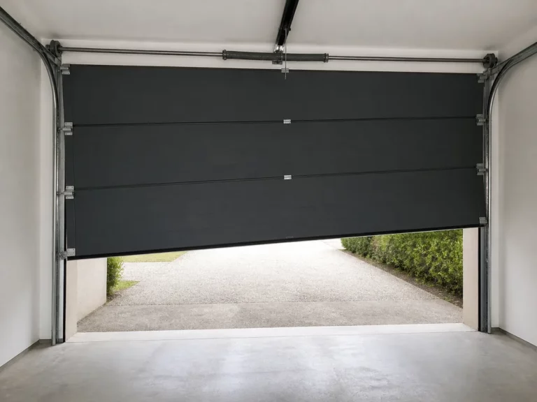 Porte de garage sectionnelle arrêtée de travers en position haute, signe d'un câble sorti de son tambour