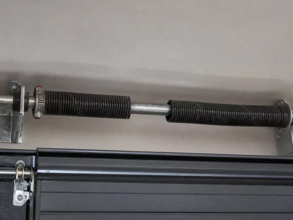 Ressort de torsion de porte de garage sectionnelle rompu, spires écartées de part et d'autre de la cassure